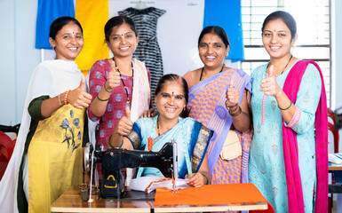 Woman with trainers around showing thumbs up by looking at camera while learning tailoring at class...