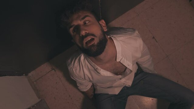 drugs, addiction - stoned man with drug-twisted eyes sitting on the ground 