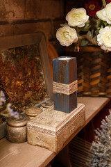 A candle in a wooden stand on a box