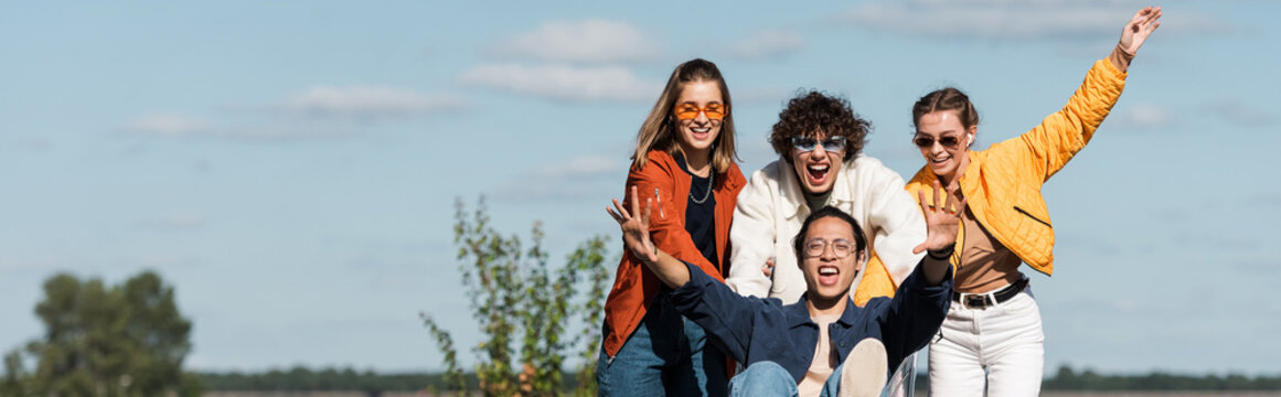 Excited Asian Man Screaming While Having Fun With Friends Outdoors, Banner.