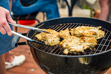 Hand of young man chef grilling some meat outdoor