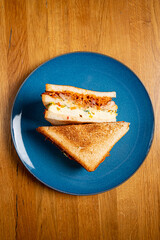 Sandwich with ham, cheese, tomatoes, lettuce, and toasted bread.
