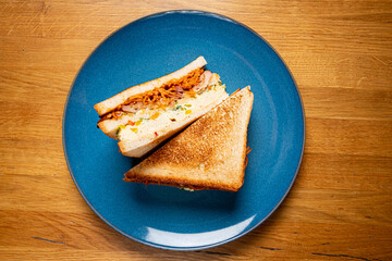 Sandwich with ham, cheese, tomatoes, lettuce, and toasted bread.