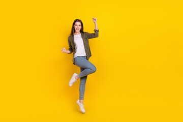 Fototapeta na wymiar Full length photo of overjoyed good mood girl jumping up in excitement win money prize isolated on yellow color background
