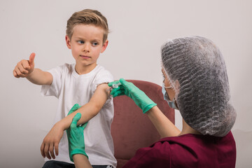 Boy getting flu shot. Cropped nurse giving child intramuscular antivirus injection. Vaccination for...