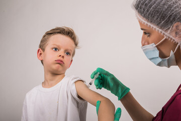Boy getting flu shot. Cropped nurse giving child intramuscular antivirus injection. Vaccination for...