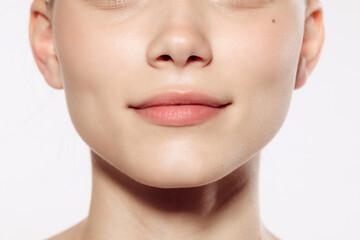 Obraz premium Closeup female lips, cheeks and nose isolated over white studio background. Concept of cosmetology, skincare, cosmetics, plastic surgery, ad