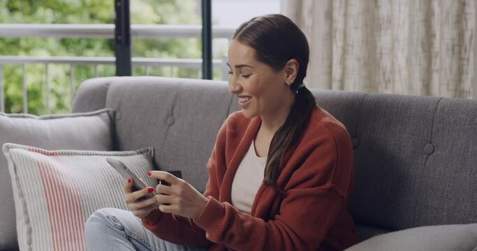 Woman cheering while online shopping for bargains and sales from home with phone and credit card. Excited consumer and happy shopper saving on awesome deals and discounted booking while spending money