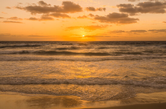 Golden Sky With Sun And Calm Ocean At Sunset