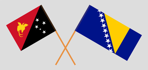 Crossed flags of Papua New Guinea and Bosnia and Herzegovina. Official colors. Correct proportion