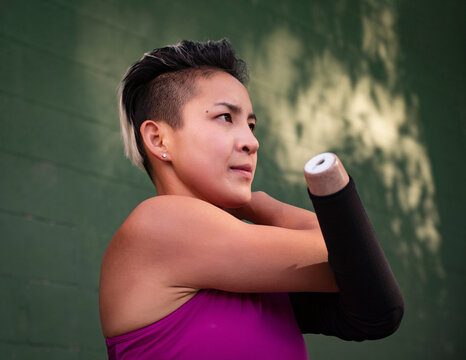 Athletic woman with amputated hand stretching arm