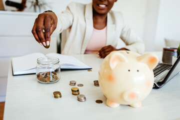 Woman hand putting money coin into piggy for saving money wealth and financial concept. Closeup...