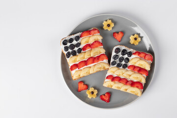 American flag sandwiches with fruit and cream cheese on rye bread on gray plate on white...