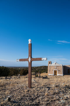 USA, New Mexico, Golden, San Francisco de Asis Church with old wooden cross in foreground