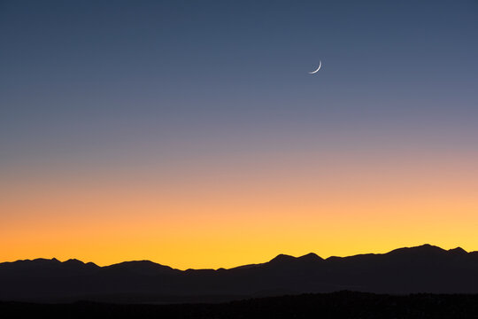USA, New Mexico, Santa Fe, Jemez Mountains at dusk with crescent moon on sky