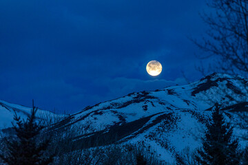 USA, Idaho, Bellevue, Full moon over snow covered hills at night