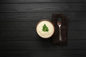 Cream of cauliflower soup on a dark wooden background.