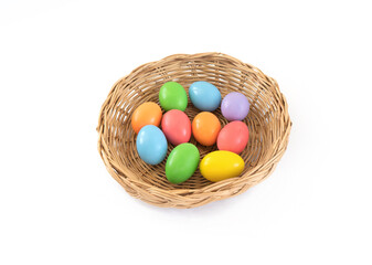 Fototapeta na wymiar Colorful easter eggs on a basket and white background. Food decoration on holiday.