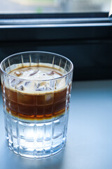 isolated glass of cold espresso tonic coffee with ice, beverage and summer drinks refreshment on minimal background