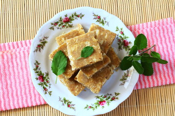 closeup of popular indian gujarati traditional sweet sukhdi or gol papdi,in india state wise various name of this sweet - obrazy, fototapety, plakaty