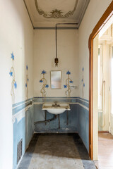 Front view of wash basin with a mirror above. Detail of a frescoed room