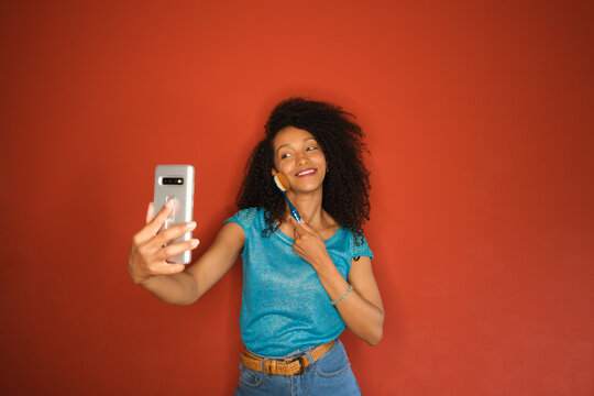 Social media influencer doing streaming video with her smartphone giving makeup beauty tips.