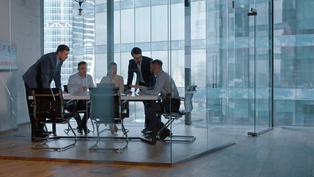 Group of business people working with technology at a meeting in a conference room