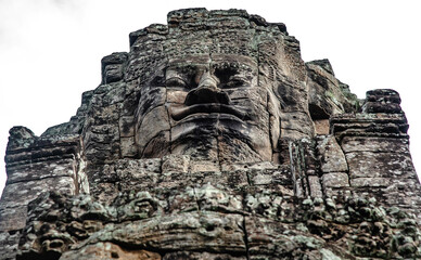 A large figure carved face on sandstone in the pagoda of Bayon Angkor Thom Temple, Siem Reap,...
