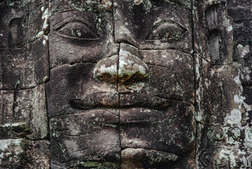 A large figure carved face on sandstone in the pagoda of Bayon Angkor Thom Temple, Siem Reap,...