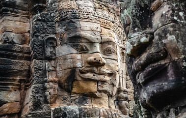 Fototapeta premium A large figure carved face on sandstone in the pagoda of Bayon Angkor Thom Temple, Siem Reap, Cambodia.