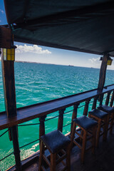 View from an old wooden boat with chairs while it cruises on the sea