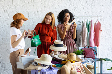 Young women at swap home party - clothes, shoes, bags, jewellery exchange between friends. Zero...