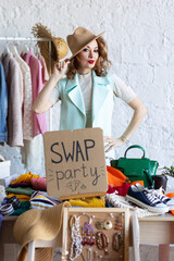 Young women at swap home party - clothes, shoes, bags, jewellery exchange between friends. Zero...