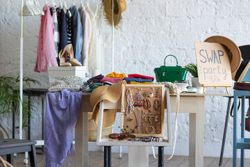Young women at swap home party - clothes, shoes, bags, jewellery exchange between friends. Zero...