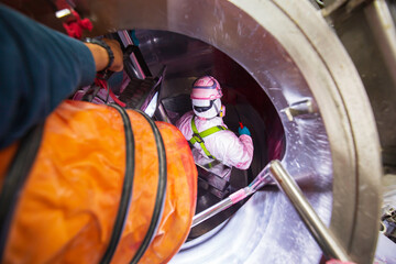 Inside male two worker into the inspection shiny tank stainless chemical  blower fresh air