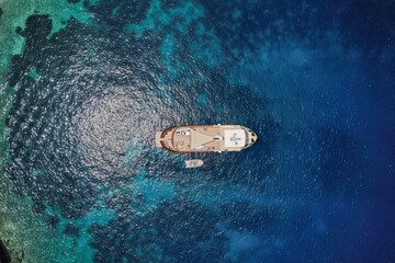 Aerial drone top down photo of luxury yacht anchored in tropical exotic island bay with crystal...