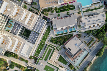 Aerial drone view of beautiful beach front hotel resort with swimming pool, umbrellas and turquoise sea. Paradise destination, Corfu, Greece. 