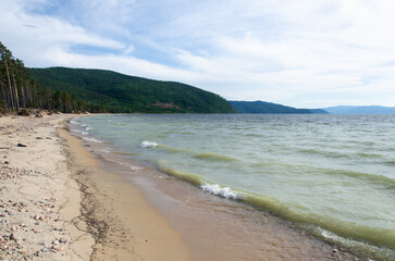 Sandy shore of Lake Baikal in summer weather.