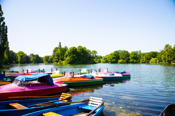 colorful pedal boats for hire in the English Garden in Munich, tourism - obrazy, fototapety, plakaty