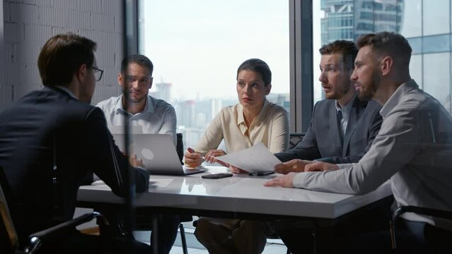 Job interview of a businessman in a suit and a business team sitting at desk