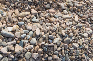 Large smooth stones on the coast. The background is made of pebbles.