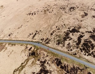 Aerial view looking down onto a road running through remote countryside. 
