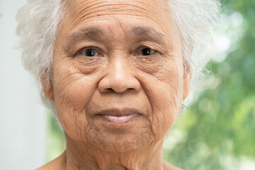Asian elderly old woman face and eye with wrinkles, portrait closeup view.