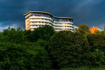 A strange block protruding from the trees with storm clouds behind it