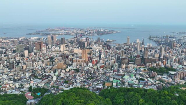 Slow aerial move over Mt. Rokko towards downtown Kobe and Port Island