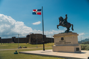 View of the fortress Fortaleza San Felipe and General Gregorio Luperon statue in Puerto Plata - obrazy, fototapety, plakaty