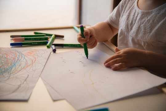 Kid drawing colorful shapes on white paper. Kids school education