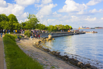 Fototapeta na wymiar Tourists near famous monument The Little Mermaid in Copenhagen