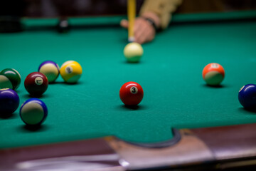 the ball with number 3 at which the cue ball is aiming. a man plays billiards in a bar. snooker.