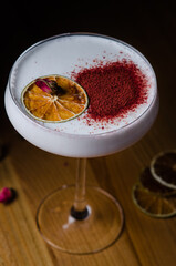 alcoholic cocktail at the bar sprinkled with cocoa and garnished with dried lime.